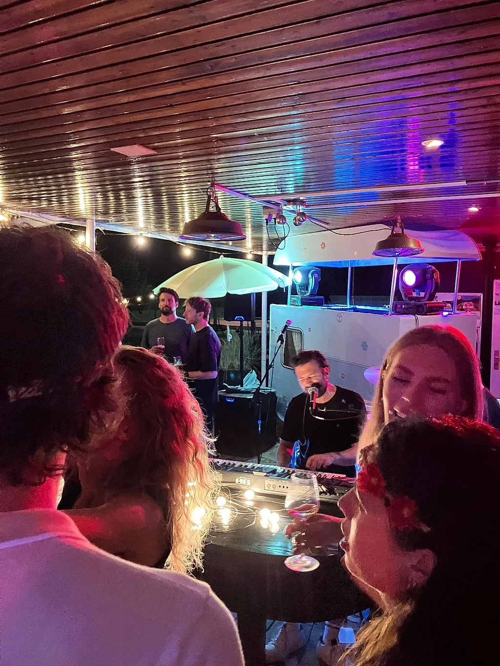 Gasten aan een tafel vlak bij de band, met de pianist op de achtergrond