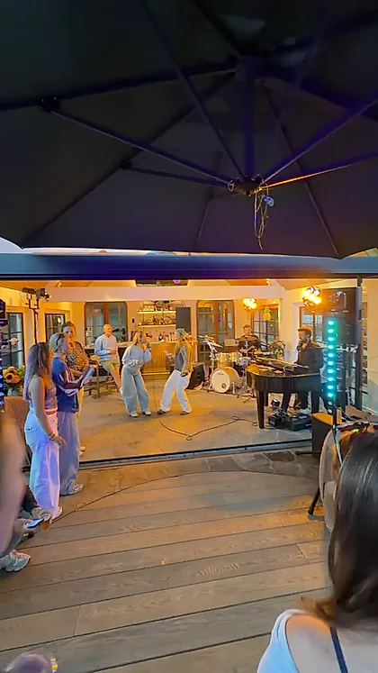 Gasten bij een tuinfeest in de avond terwijl de band speelt