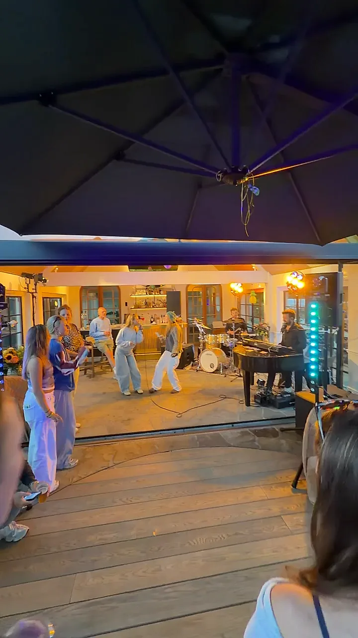 Gasten bij een tuinfeest in de avond terwijl de band speelt