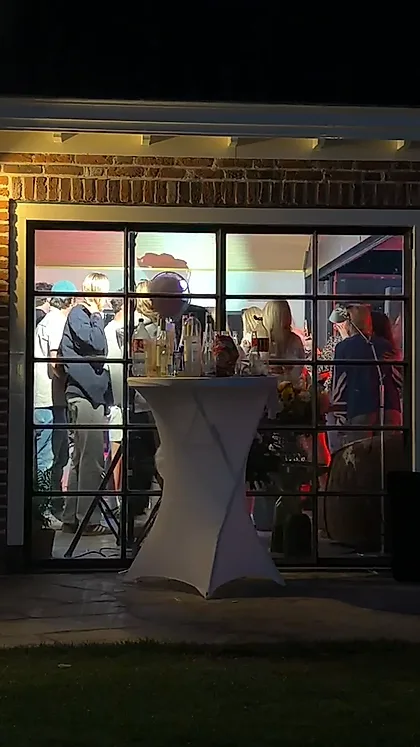 Een volle zaal gezien vanaf buiten, met gekleurd licht binnen